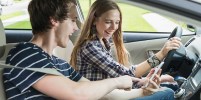 Two teenagers in a car, girl driving